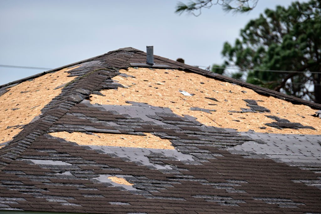 A storm damaged roof with missing shingles